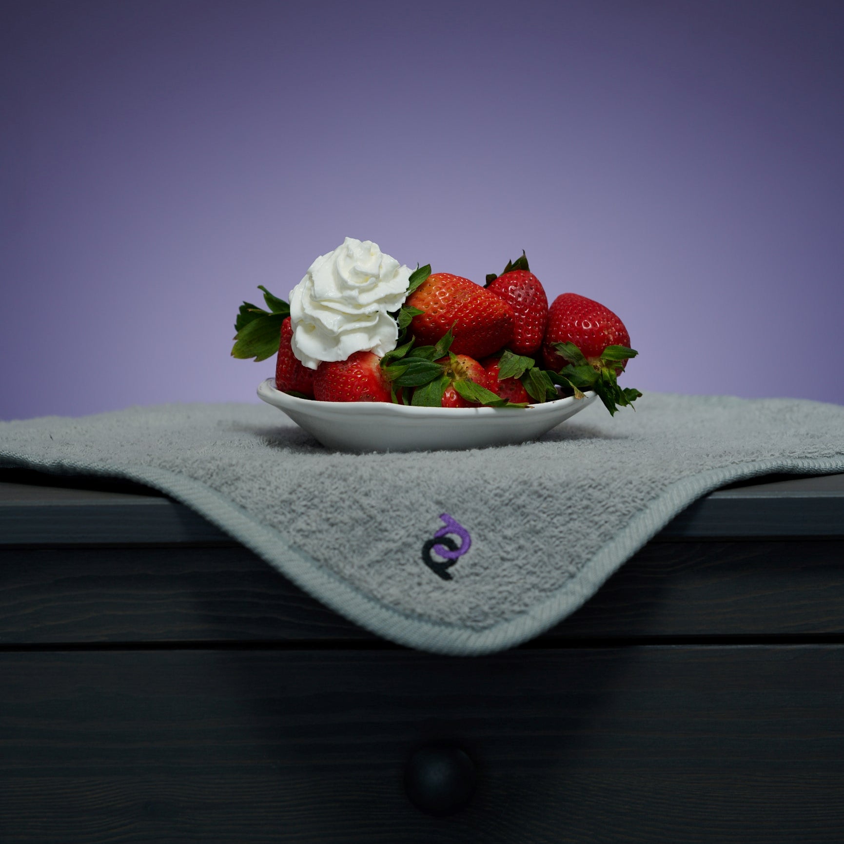 strawberries with whipped cream in bowl above grey playdrop sex mat 