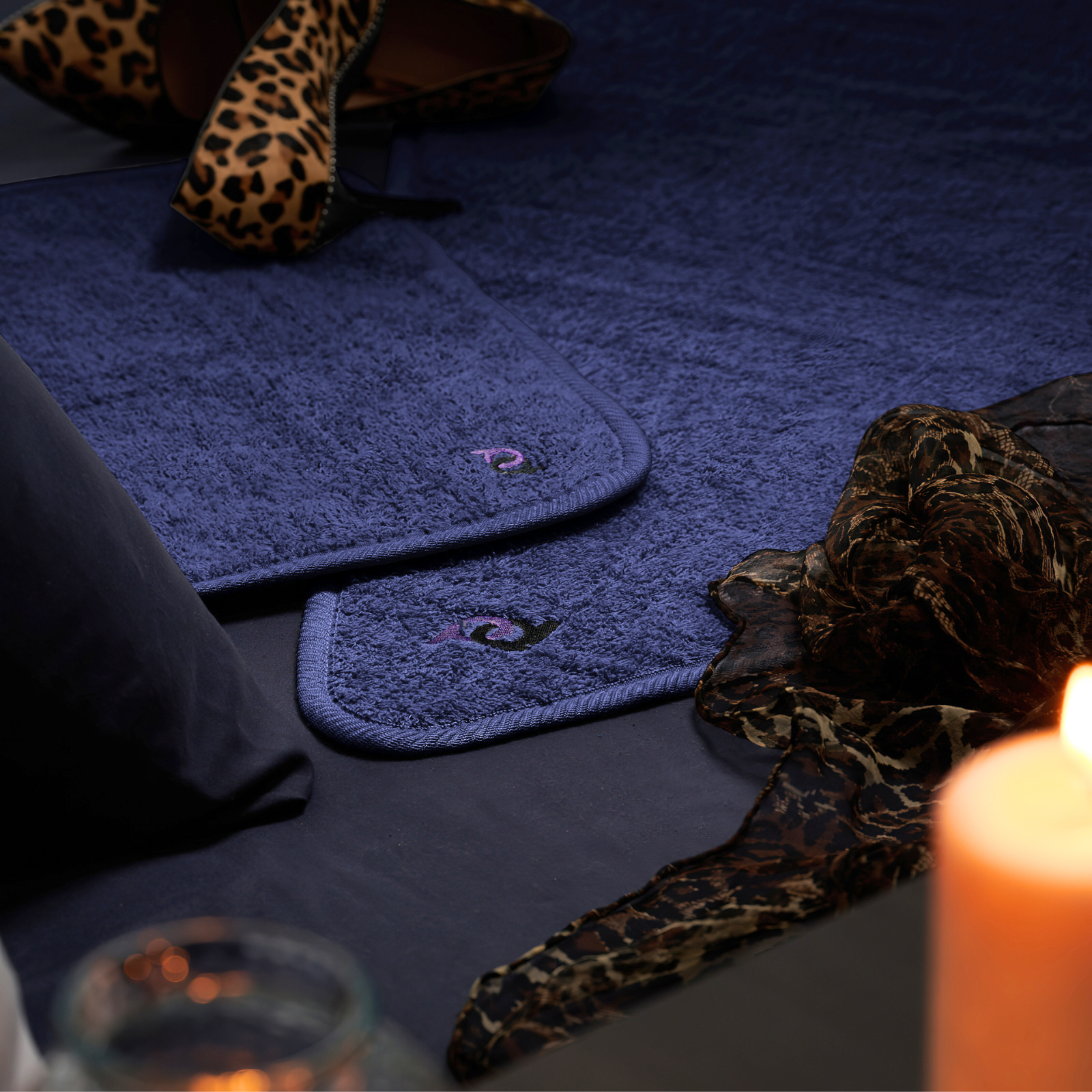 royal blue coloured sex mat displayed in romantic ambience with candles and cheetah print attire